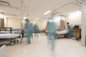 healthcare workers in a hospital with one of them moving at a fast and dangerous pace