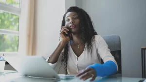 woman with an injured arm on the phone with her workers comp lawyer asking them if I get injured at work do I get paid