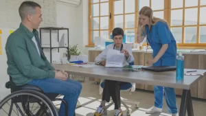 social security medical examiners and an injured patient sitting in wheelchair at an official disability medical exam