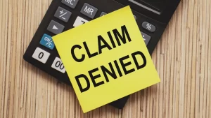 claim denied sign on top of a calculator