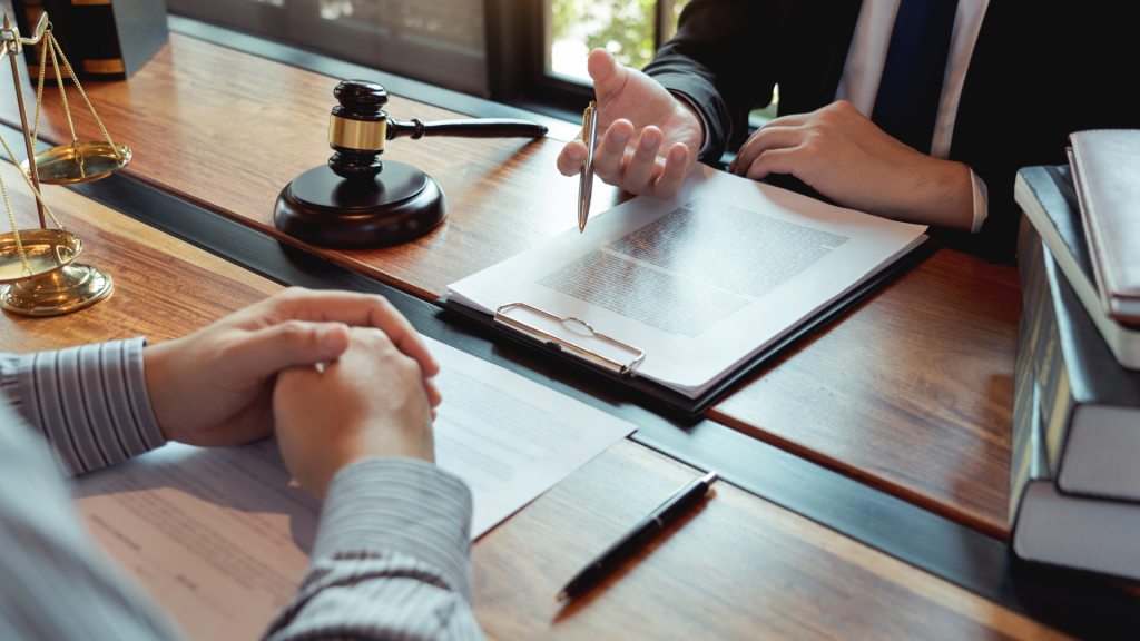 Lawyer and client discussing legal documents with a gavel on the table.